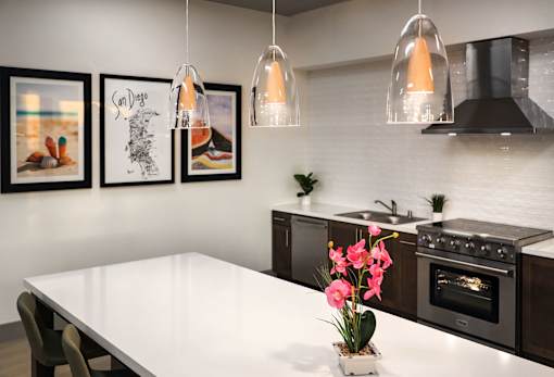A kitchen with a white table and black appliances.