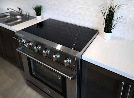 A modern kitchen with a stainless steel oven and a white countertop.