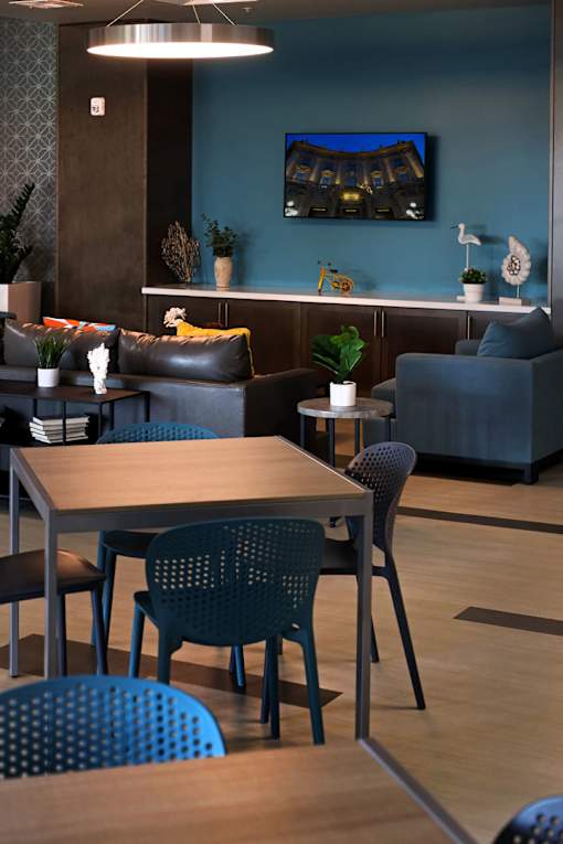 A modern living room with a TV, couch, and chairs.