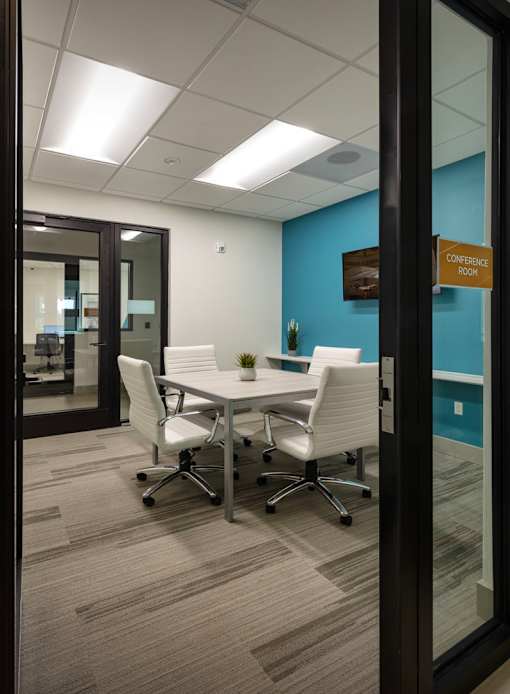 A conference room with a table and chairs.