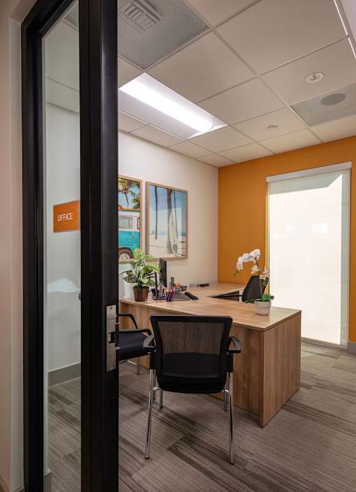 A modern office with a glass door and a sign that says "OFFICE".