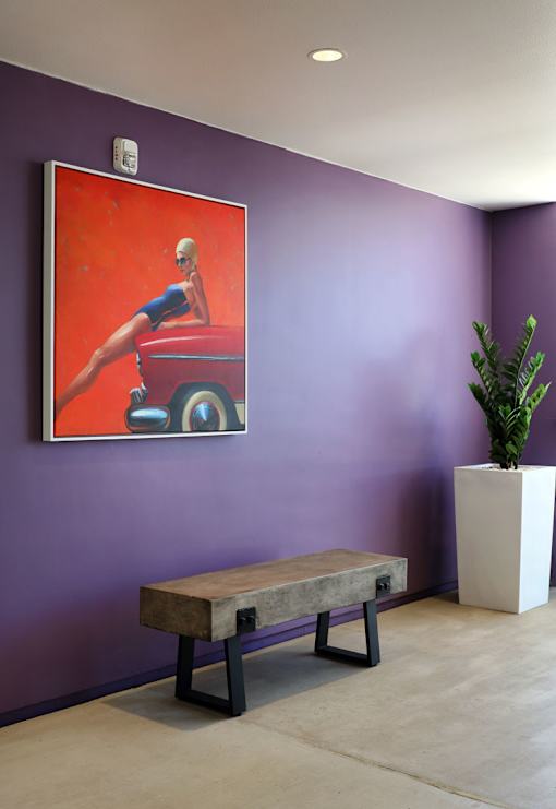 A woman is sitting on a red car in a painting.