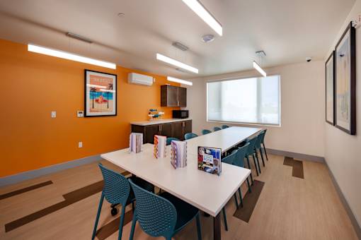 A conference room with a long table and chairs.