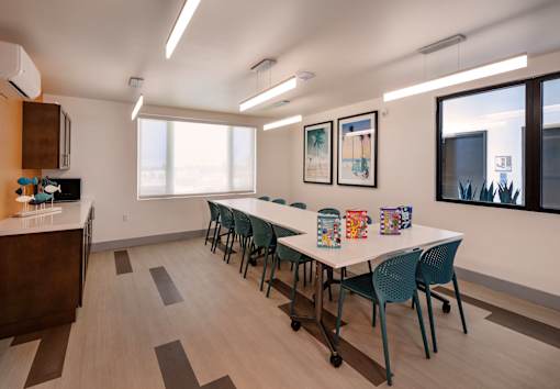 A conference room with a long table and chairs.