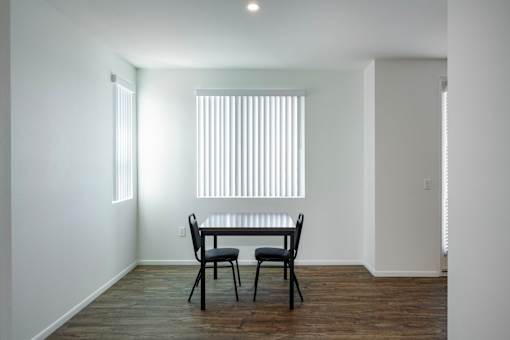 A dining room with a table and chairs.