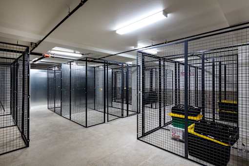 A room with multiple black cages and a concrete floor.