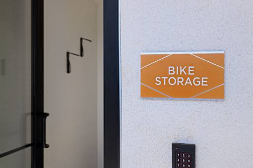 A sign that says Bike Storage is on a white wall.