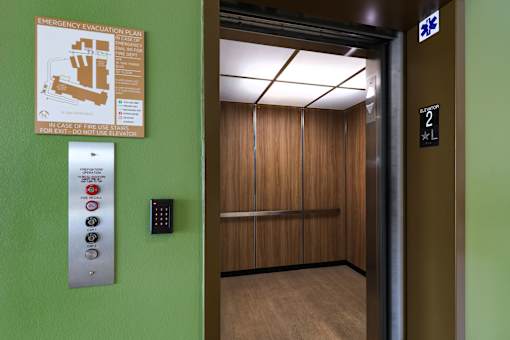 An elevator with a green wall and a sign on it.