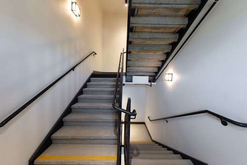 A staircase with a metal handrail and wooden steps.