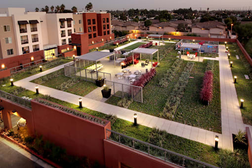 A courtyard with a fence and a green lawn.