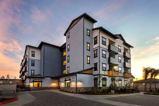 A modern multi-story residential building with a mix of grey and white exterior.