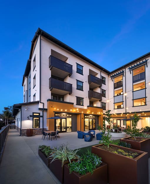 A modern building with a patio and planters in front.