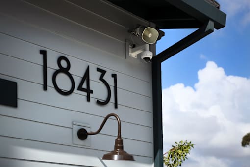 A house numbered 18431 is shown with a security camera and a light fixture.