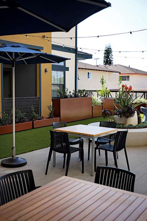A patio with a table and chairs under an umbrella.