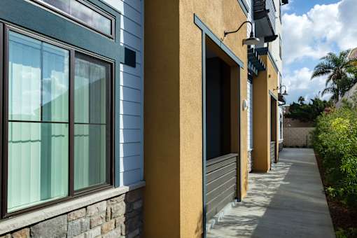 A row of houses with a sidewalk in front.