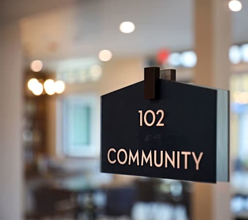 A sign that says "102 COMMUNITY" is hanging on a wall.