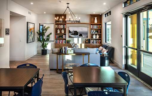 A modern dining room with a long table and chairs.