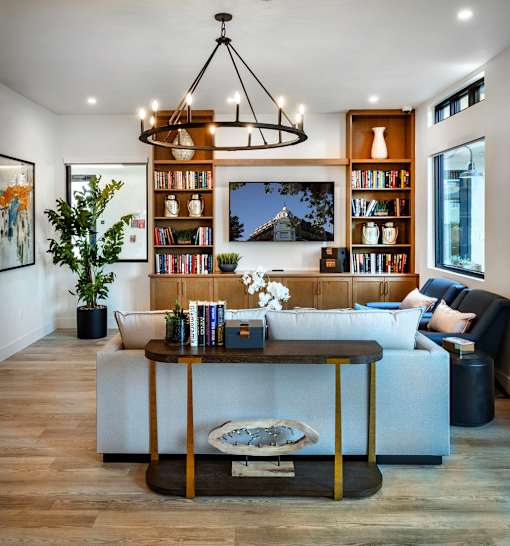A living room with a white couch, a coffee table, and a bookshelf.