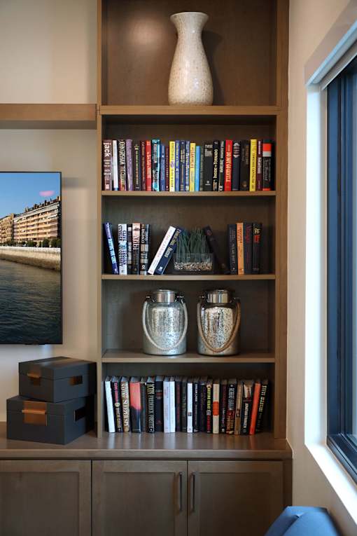 A bookshelf filled with books and decorative vases.