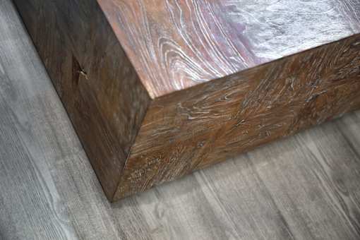 A wooden box with a metallic finish on one side is placed on a grey surface.