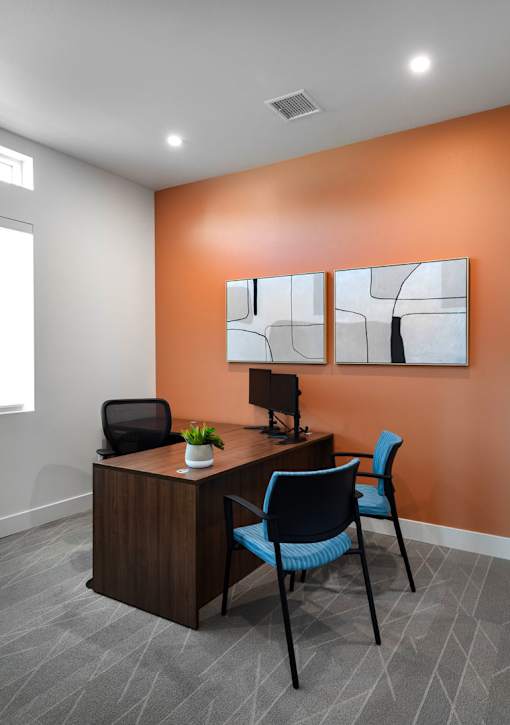 A modern office with a wooden desk and blue chair.