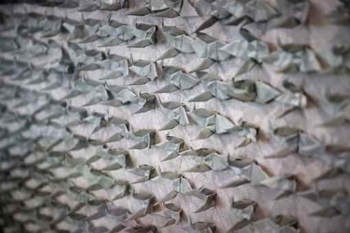 A close up of a pattern made of origami fish.