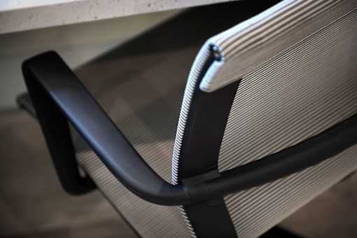 A close up of a black and grey chair with a black armrest.