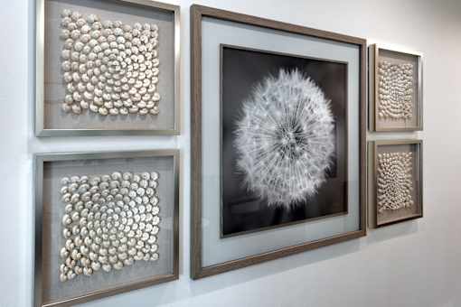 Four framed artworks are displayed on a wall.