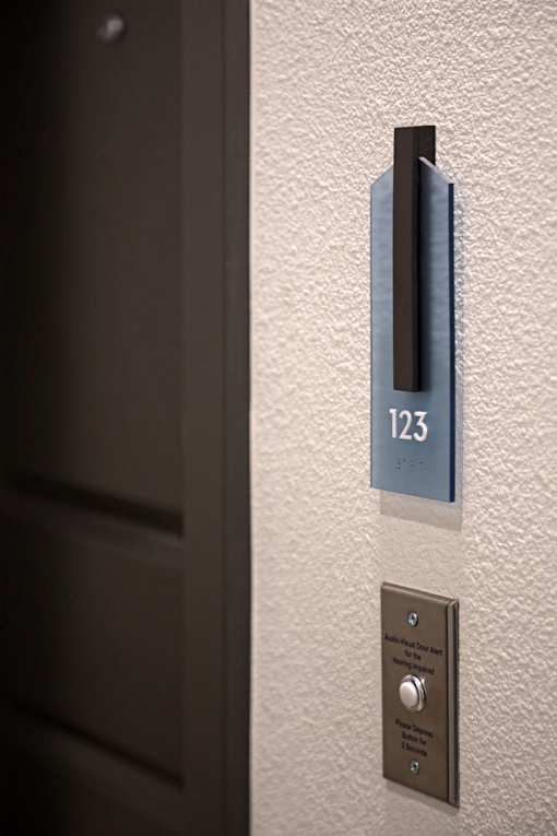 A door handle with a number plate of 123 and a button below it.