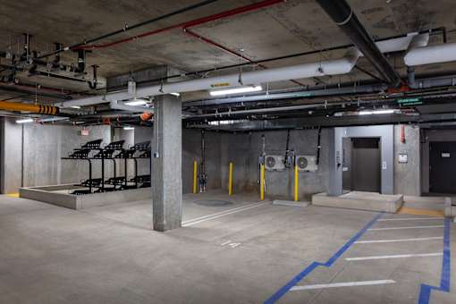 A parking garage with concrete floors and multiple parking spaces.