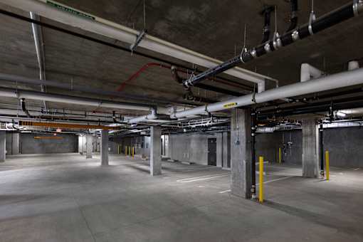A large, empty parking garage with concrete floors and multiple levels of parking.