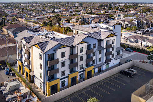 A large apartment complex with a parking lot in front.