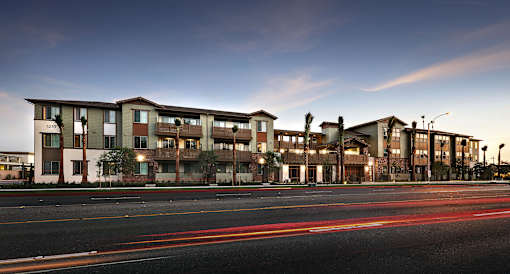 A long building with a lot of windows and lights on the street.