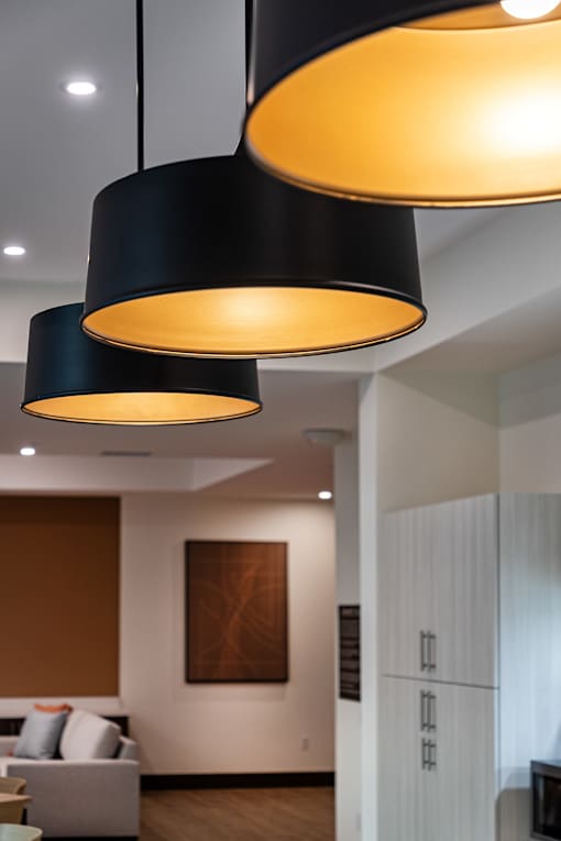 Three black lampshades hanging from the ceiling.