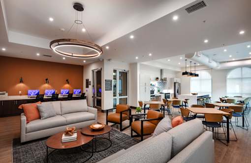 A modern living room with a grey sofa, orange pillows, and a coffee table.