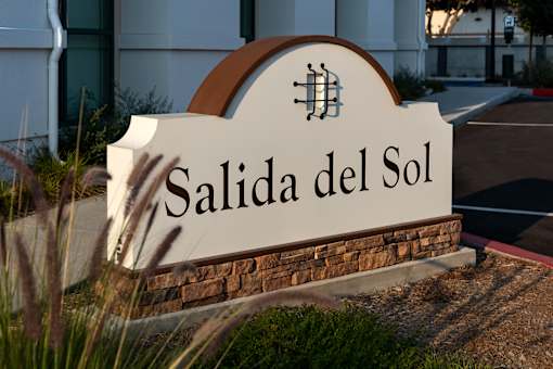 Salida del Sol sign in front of a building.
