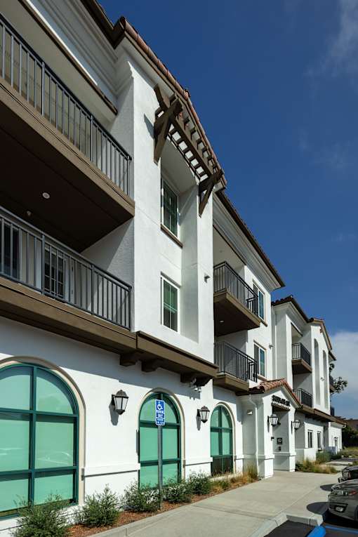 A row of apartment buildings with green doors and windows.