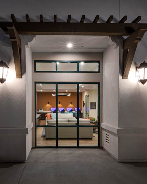 A modern house entrance with a glass door and a bench inside.