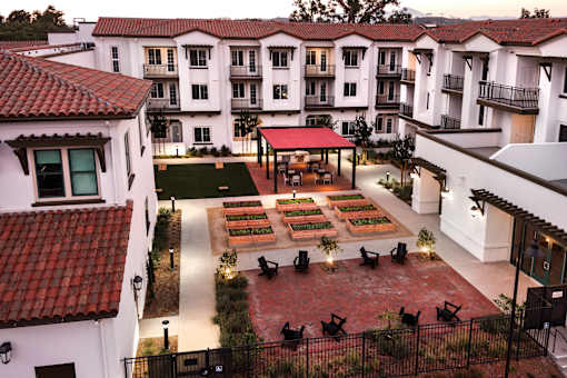 A courtyard with a red roof and a white building with balconies.