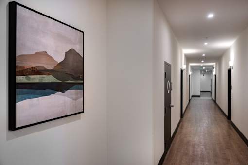 A long hallway with a painting on the wall.
