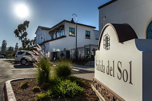 A sign that reads "Salida del Sol" is in front of a building.