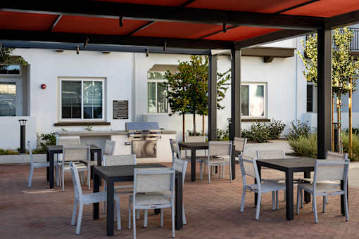 A patio with a table and chairs under a red canopy.