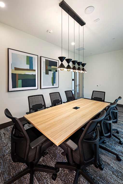 A conference room with a long table and chairs.