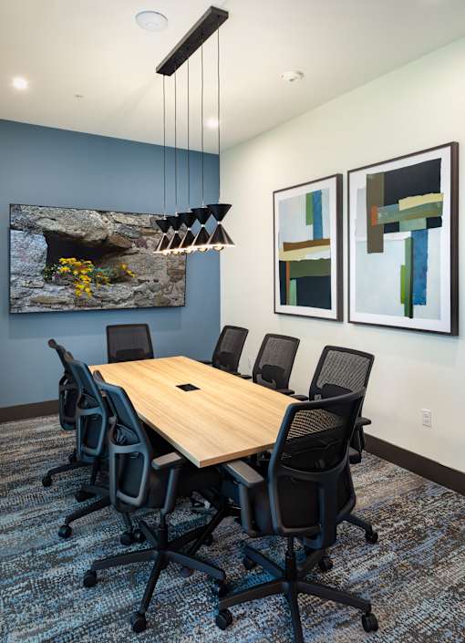 A conference room with a large table and chairs.