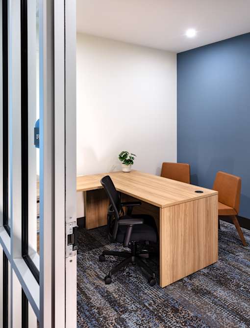 A room with a desk and chairs.