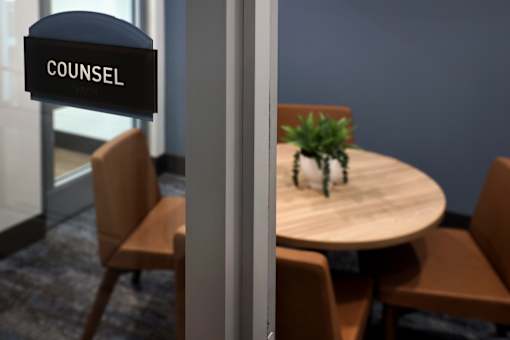 A sign that says "COUNSEL" hangs above a table with chairs.