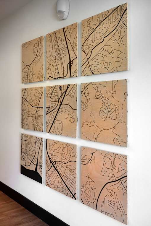 A wall with four paintings of maps on it.