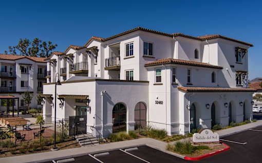 A white building with a sign that says Salida del Sol.