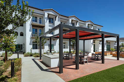 A modern building with a white exterior and a red awning.