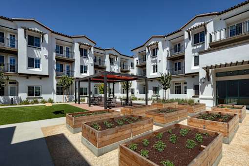 Apartment complex with a garden in front.